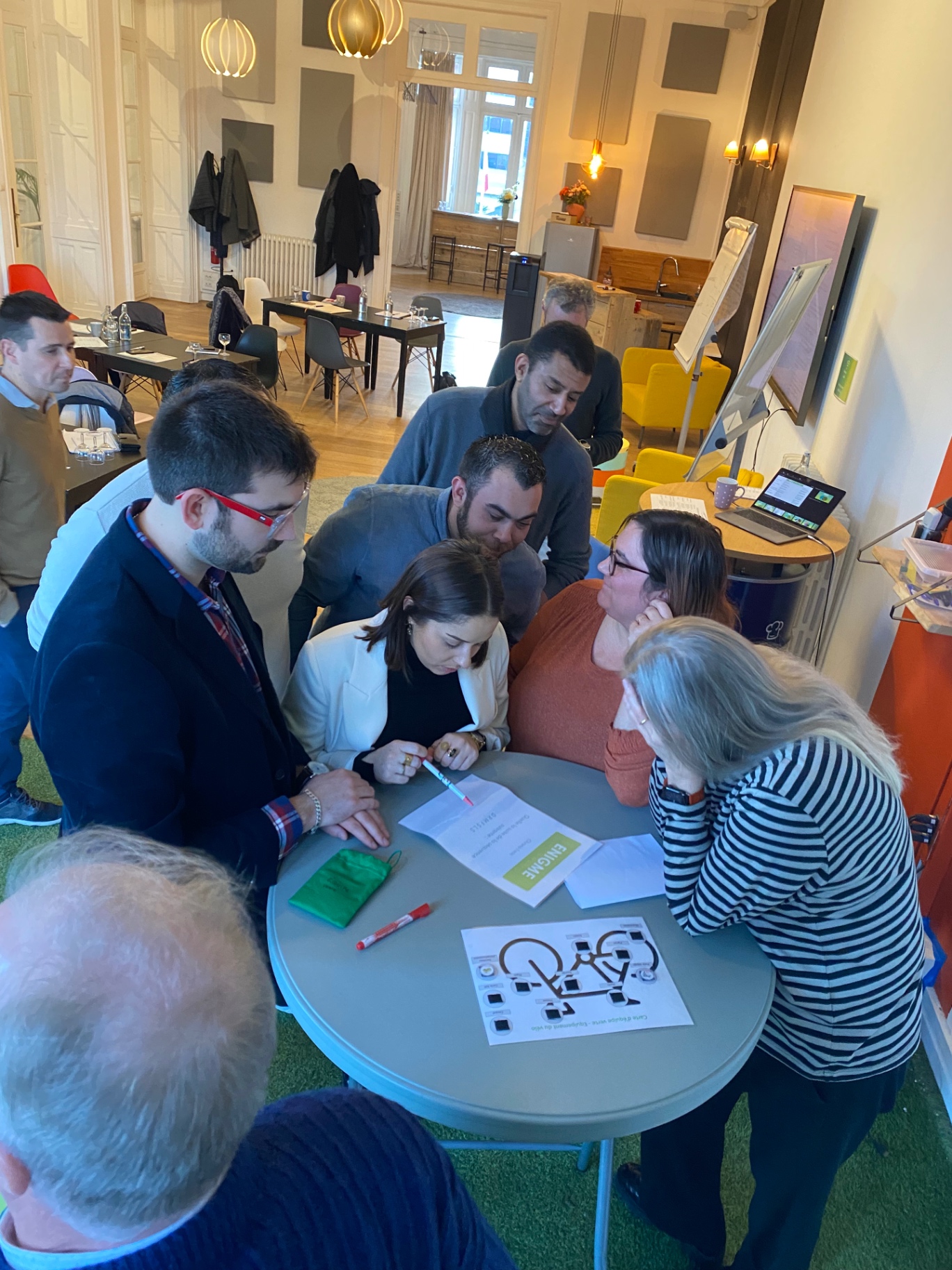 Managers debout autour d’une table, en pleine résolution collective à La Maison d'Alfred