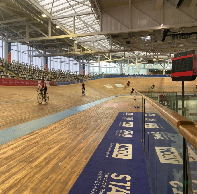 Des participants du parcours en mouvement sur la piste du vélodrome de Roubaix.